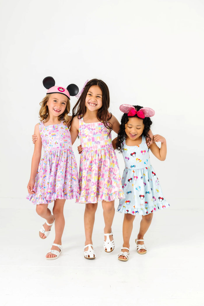 three girls in disney inspired sleeveless print twirl dresses and mouse ears for a day at the parks