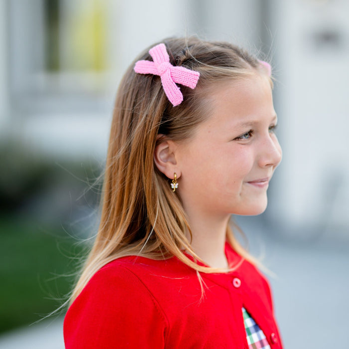 little girl wearing pink knit pigtail bows styled with red cardigan for back to school outfit
