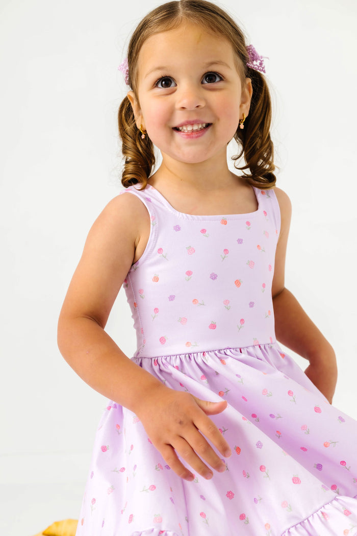 little girl twirling in light purple sleeveless twirl dress with pastel rosette print