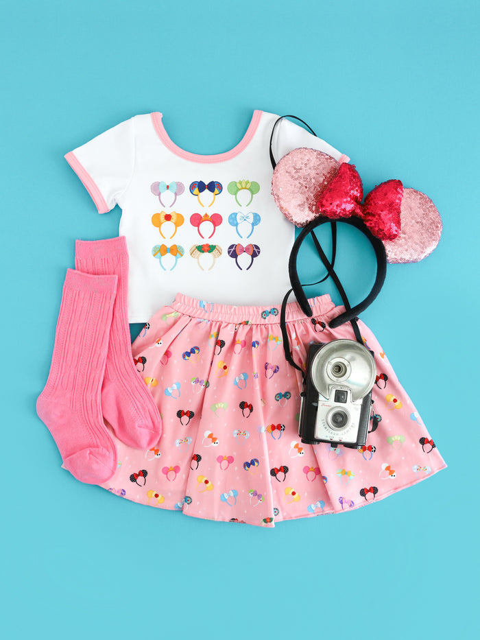 girls' white top with Disney character inspired ears print paired with pink skort with magical ears print and pink knee high socks