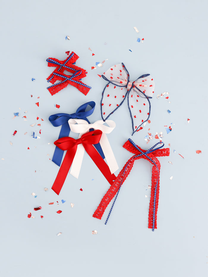 assortment of red, white and blue hair bows in satin, lace and sheer ribbons on alligator clips