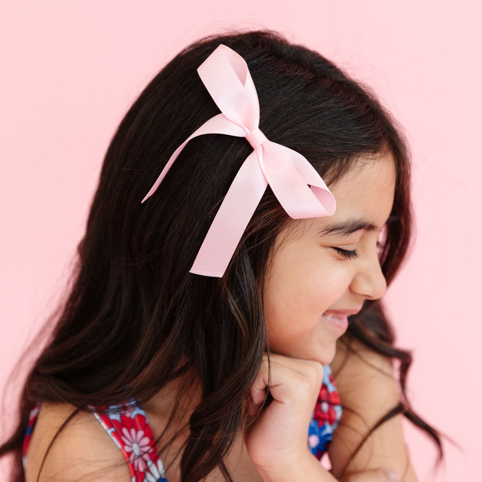 little girl with light pink satin ribbon bow on clip to match 4th of July floral print twirl dress