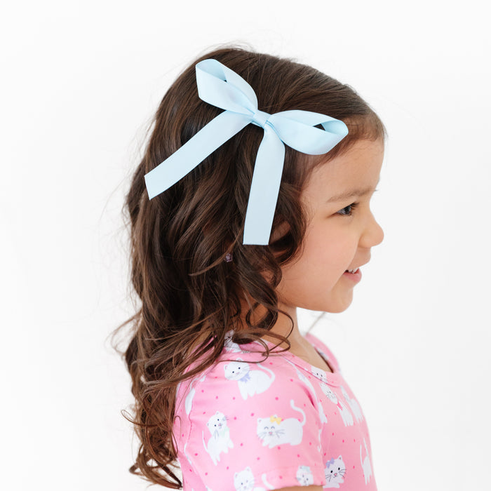little girl with light blue satin ribbon bow on clip and matching pink dress with kittens wearing bows