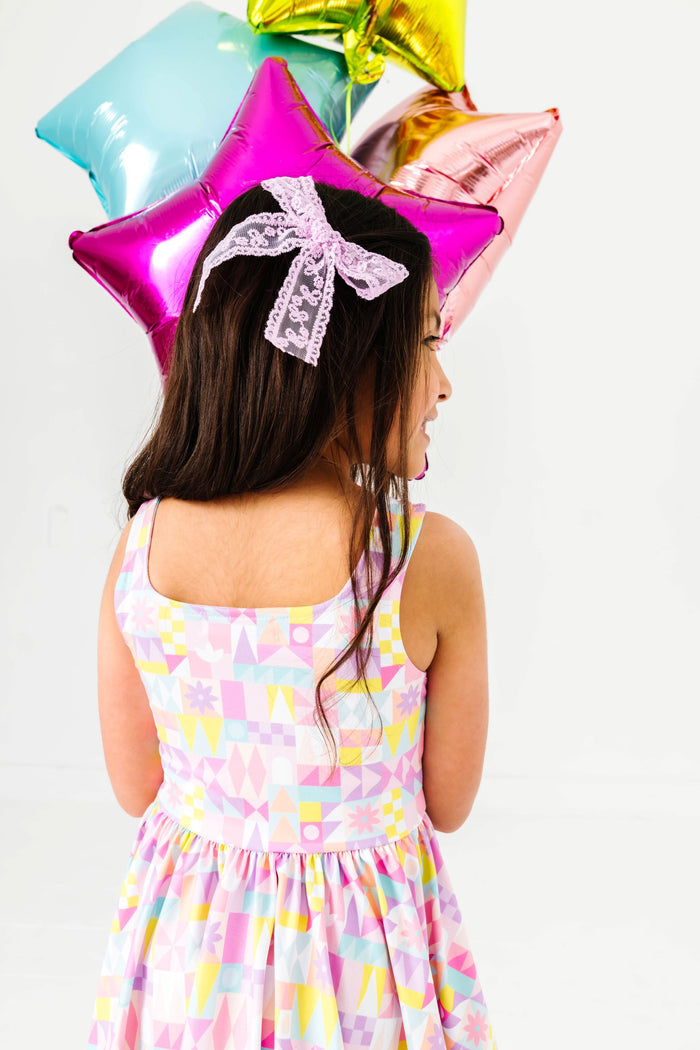 little girl holding colorful star balloons in small world inspired tank twirl with square neckline