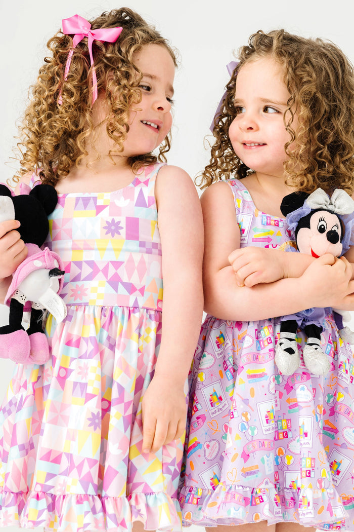 sisters in coordinating magical theme park twirl dresses with stuffed minnie toys