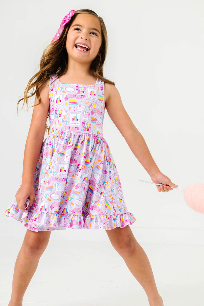 little girl holding cotton candy in purple sleeveless best day ever print twirl dress
