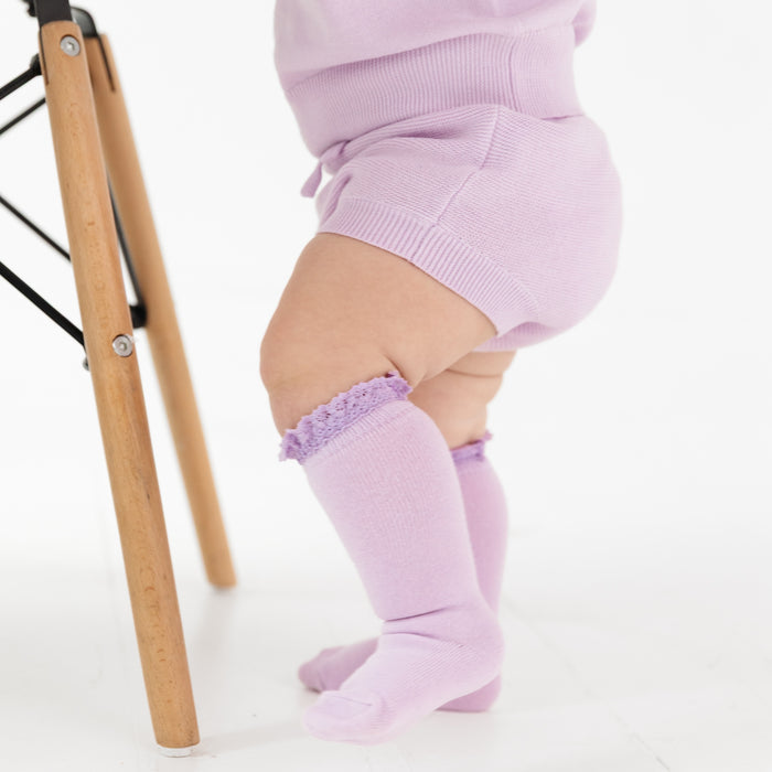baby girl in lilac cotton knit sweater bloomers with matching lace top knee highs and pullover sweater for spring