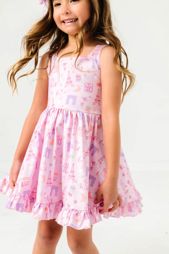 young girl twirling in Paris themed sleeveless twirl dress featuring iconic Parisian landmarks and treats