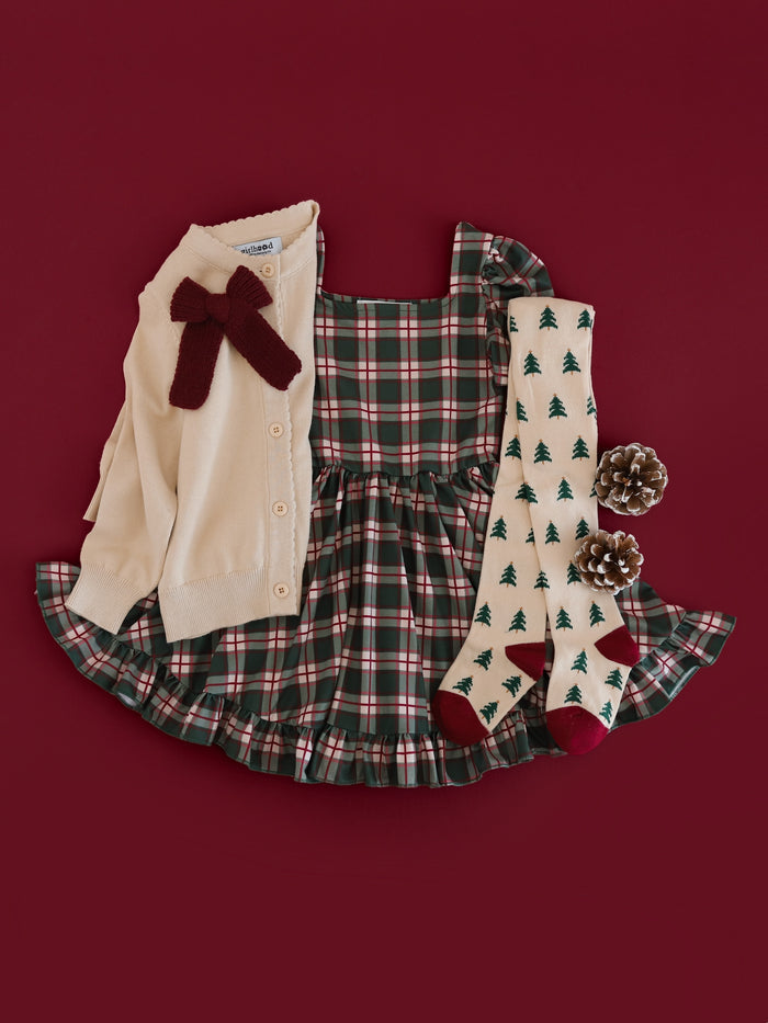 girls' forest green plaid short sleeve twirl dress paired with cream cardigan, burgundy knit bow and Christmas tree pattered tights