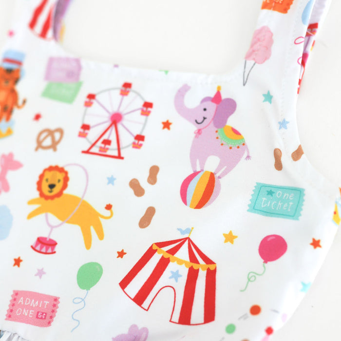 close up of twirl dress bodice featuring colorful circus animals, rides and treats on white background