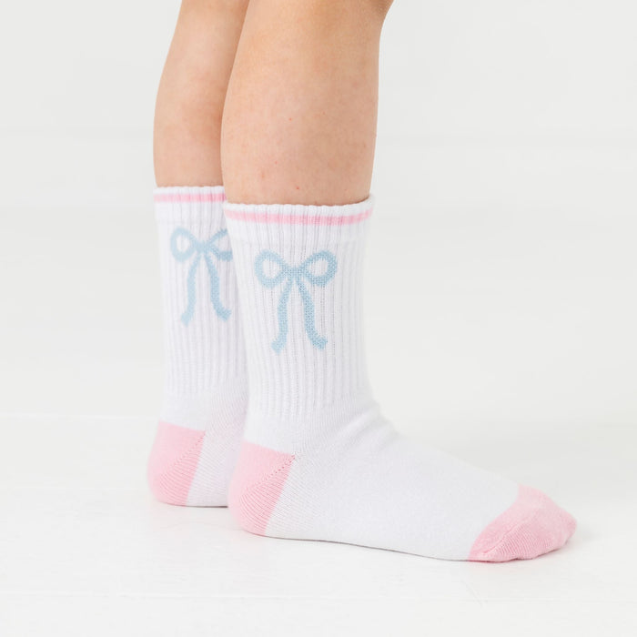 closeup of white crew socks with pink trim and blue bow design at the ankle from the teddy and bow sock three pack