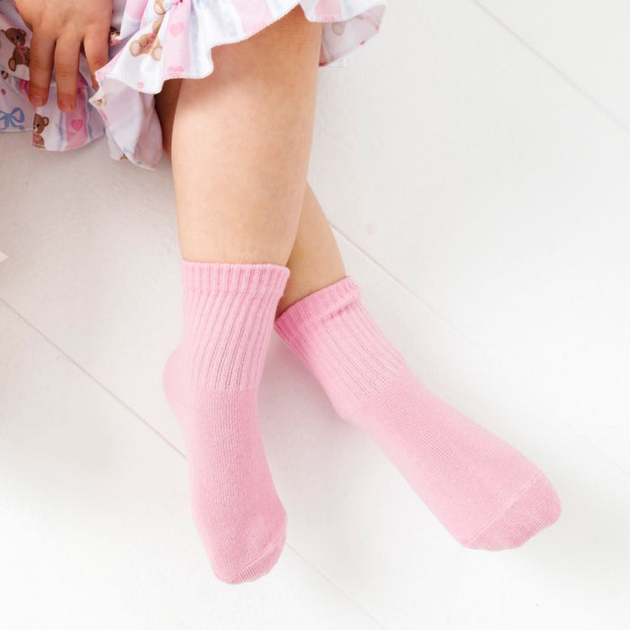 little girl sitting in light pink crew socks from teddy and bow 3-pack paired with teddy bear twirl dress