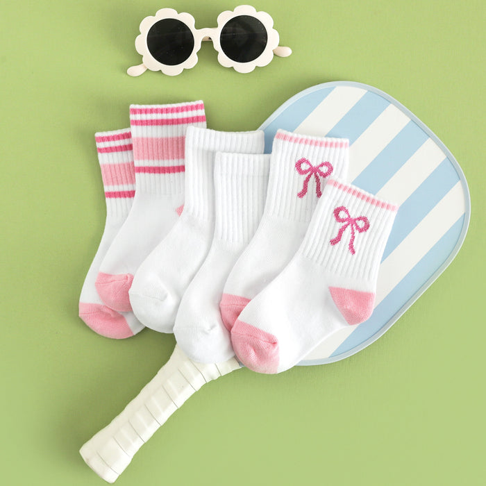 flat lay of girls pink three pack of summer crew socks with taffy pink design styled with pickleball paddle and flower sunglasses