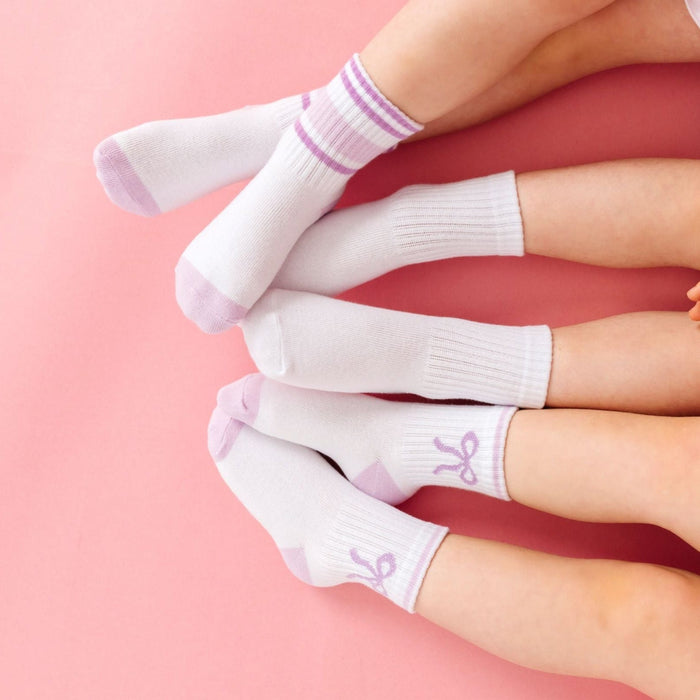 three girls in lavender crew sock three pack with striped, solid white and bow midi socks