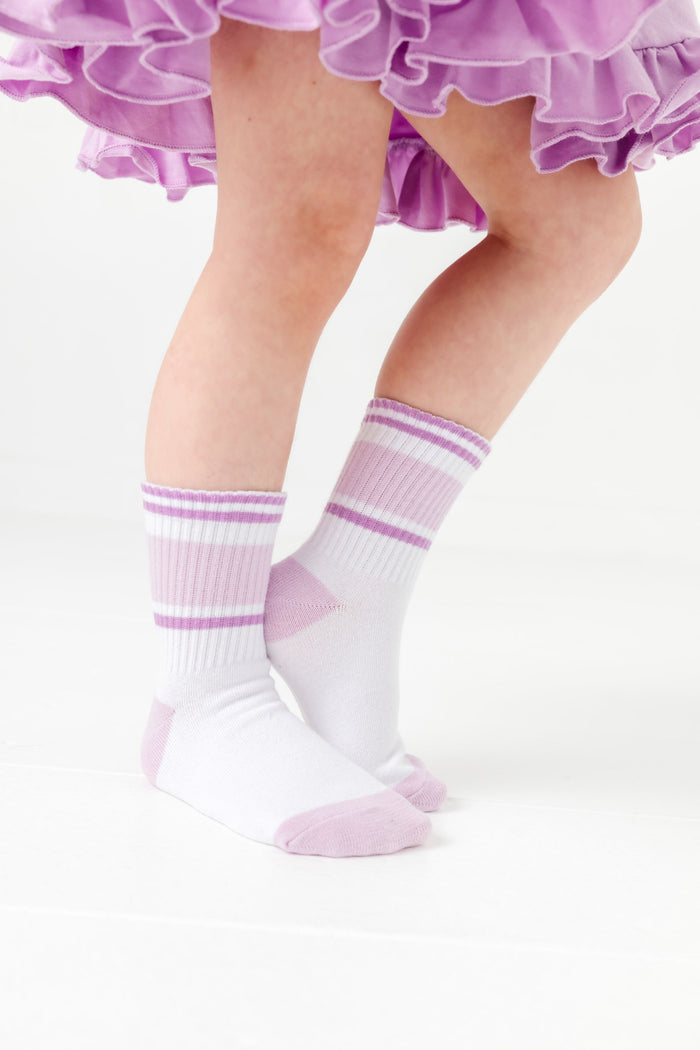 close up of little girl in white crew socks with pastel purple stripes and matching lavender twirl dress