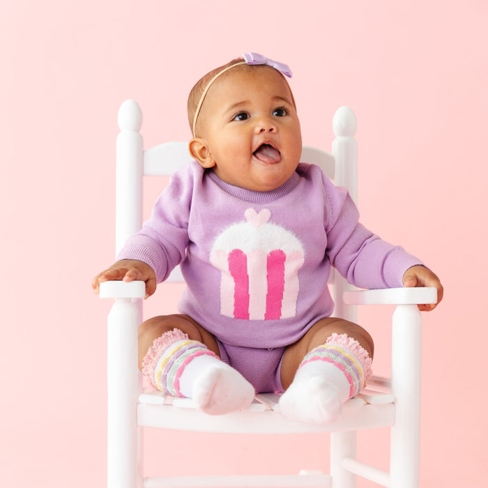 baby girl in lavender sweater with fluffy knit cupcake detail, matching bloomers, socks and bow for birthday party and Valentine's Day