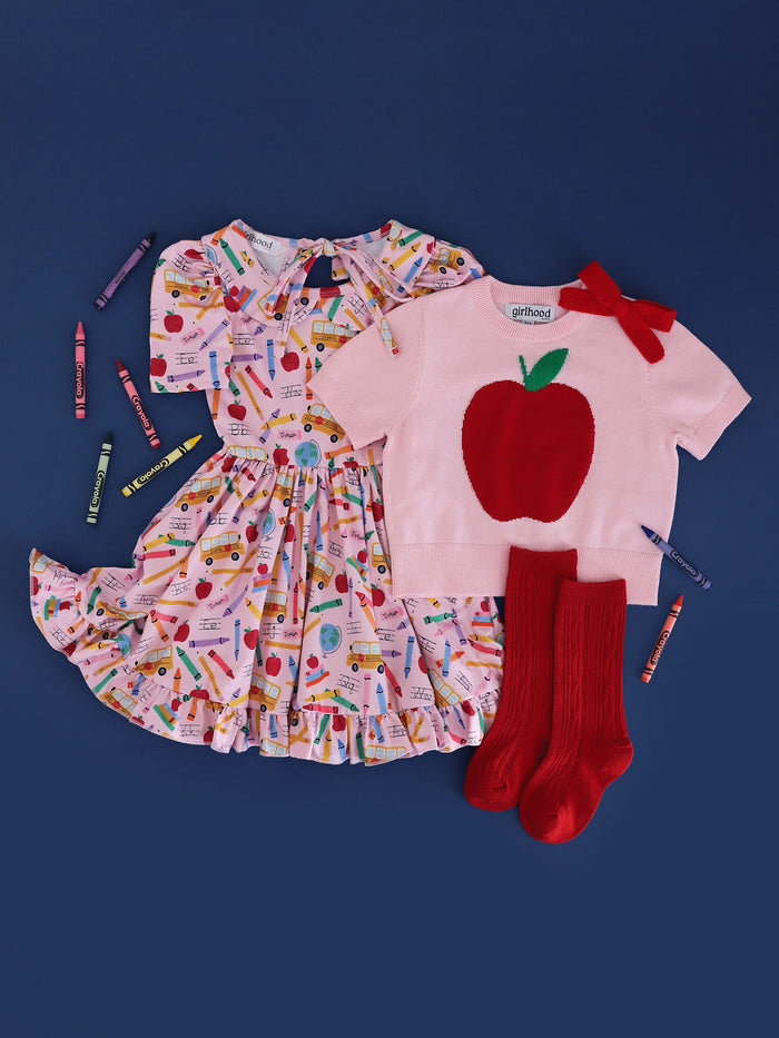 Matching back to school outfit for girls.  Pink school print dress, red apple sweater and red knee high socks