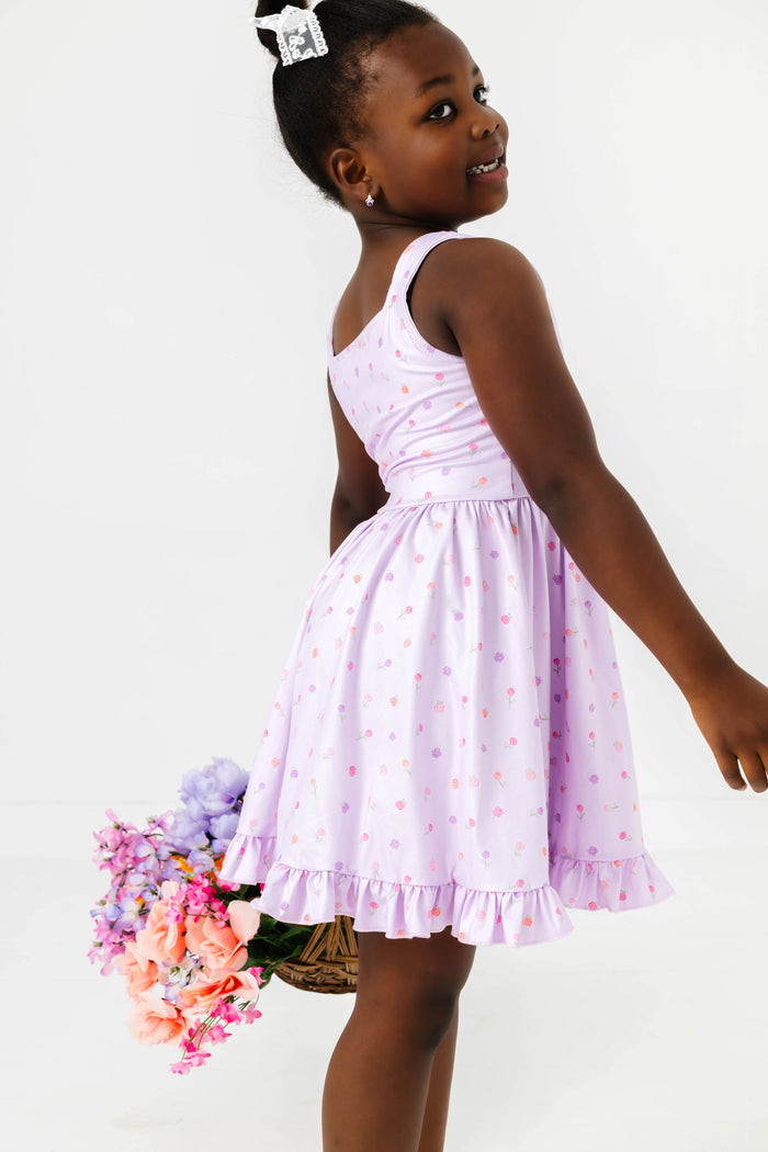 girl holding flower basket in light lavender twirl dress with pastel rosette print