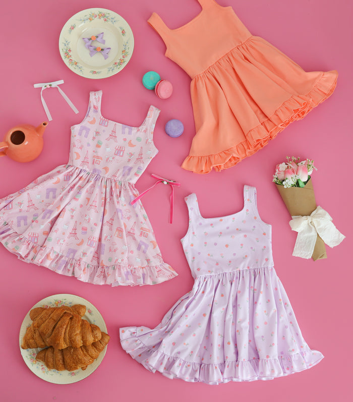 trio of coordinating Paris themed sleeveless twirl dresses styled with Parisian treats