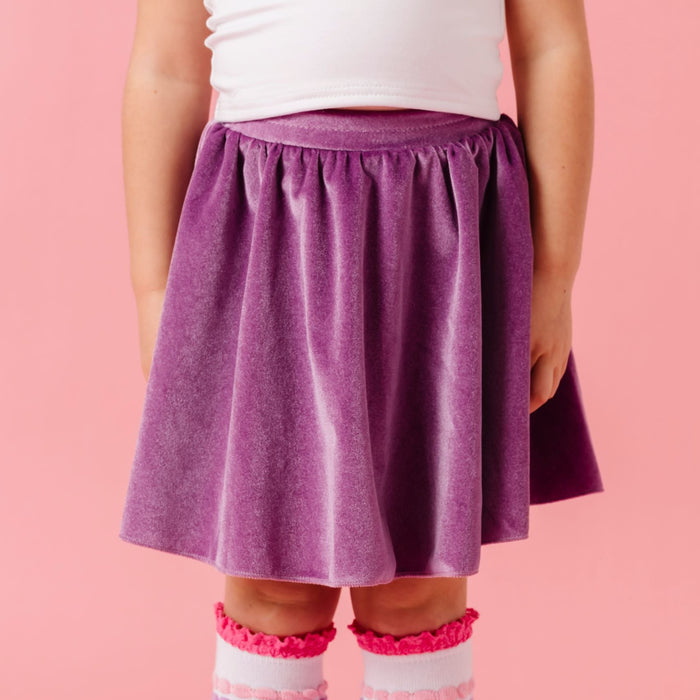 girl in pink heart top paired with lavender skort and white lace top knee highs with bubbly stripes in shades of pink and purple