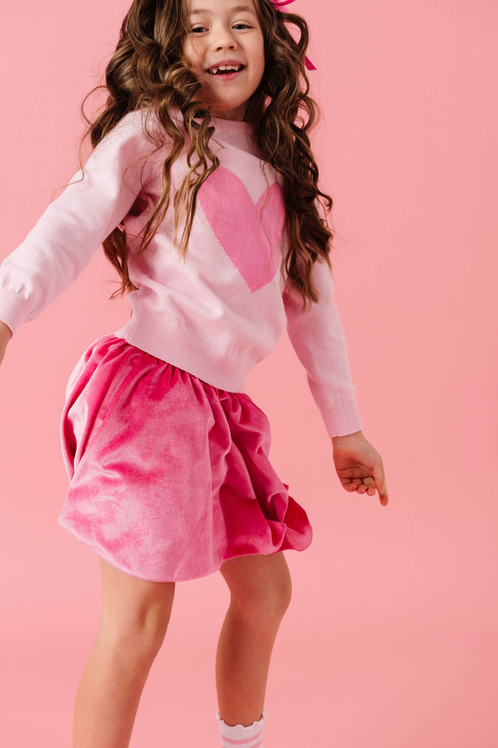 young girl dancing in two tone pink heart sweater and matching pink velvet skort for valentines day