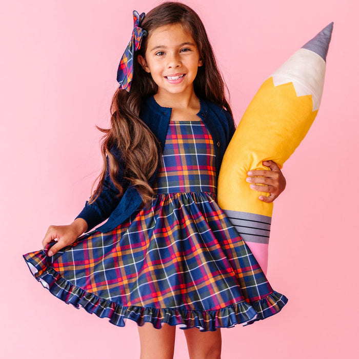 girl wearing matching back to school plaid outfit with navy sweater and socks