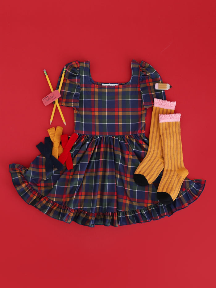 girls navy plaid school twirl dress paired with pencil inspired knee socks and matching bows in uniform colors