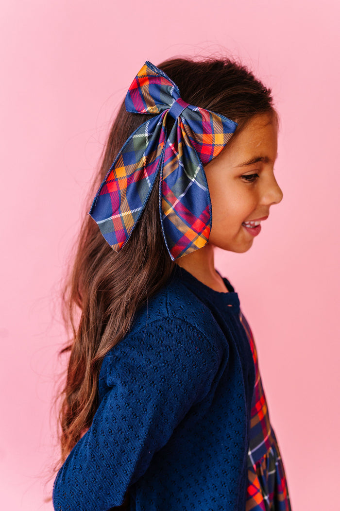 Girl wearing back to school hair bow in navy plaid print