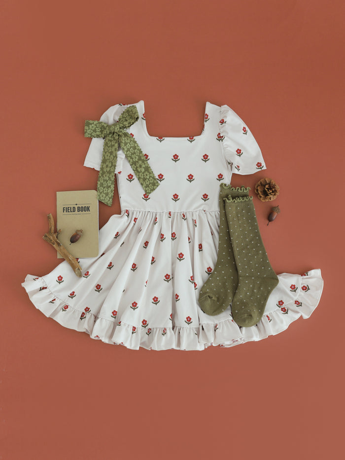 girls' light cream square neck twirl dress with rust floral print paired with olive dottie knee socks and bow