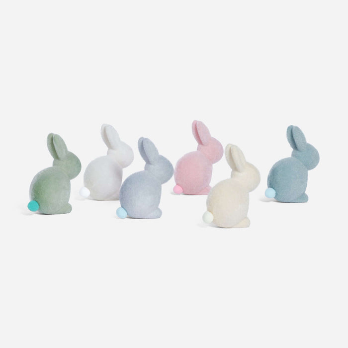 Set of pastel-colored bunny figurines on a white background