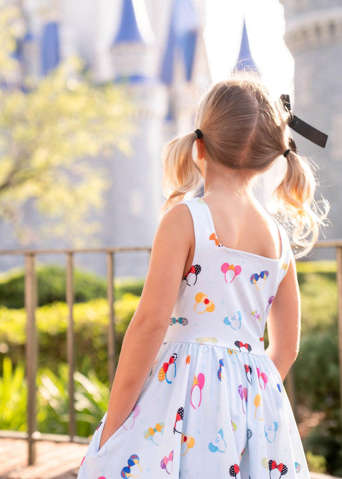 little girl in front of castle in blue magical ears sleeveless twirl dress