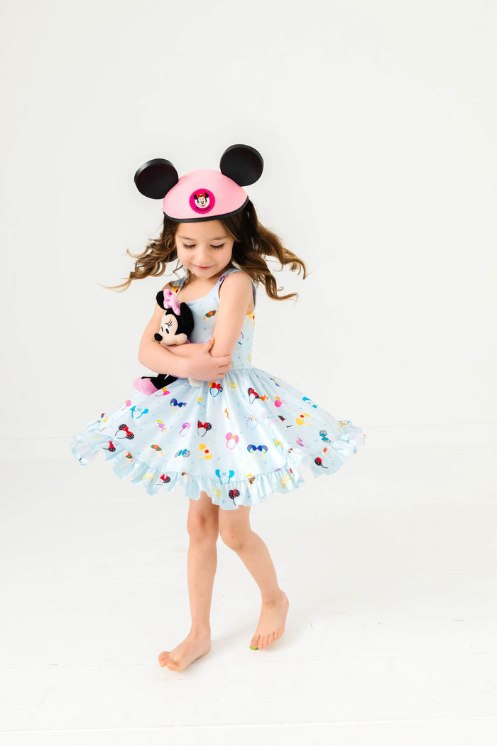 little girl twirling with minnie mouse toy in blue magical ears sleeveless twirl dress