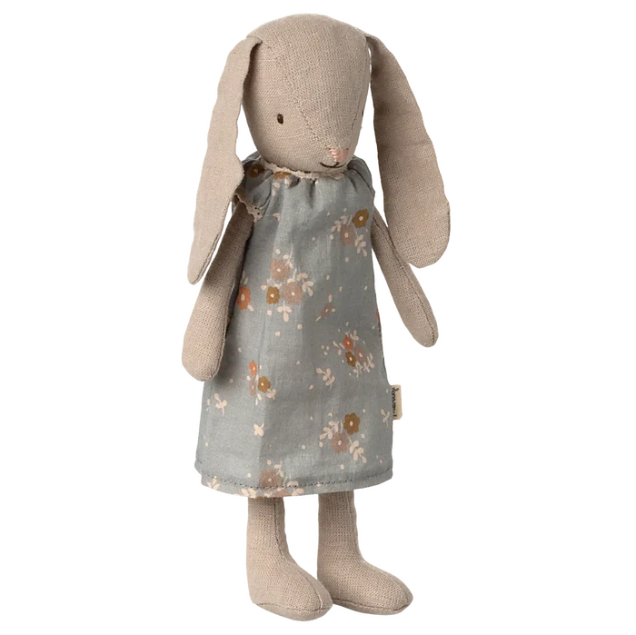 Stuffed bunny toy with a floral dress on a white background