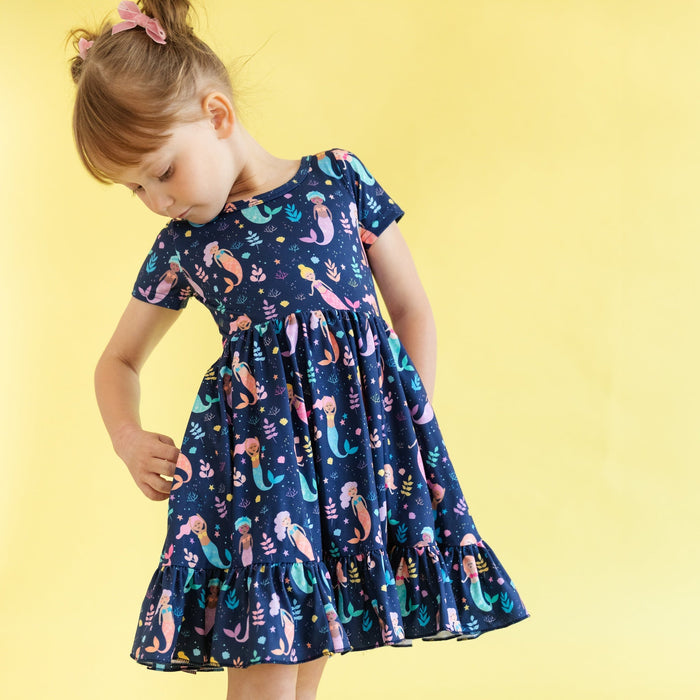 mermaid print dress on girl wearing matching pink hair bows and sandals