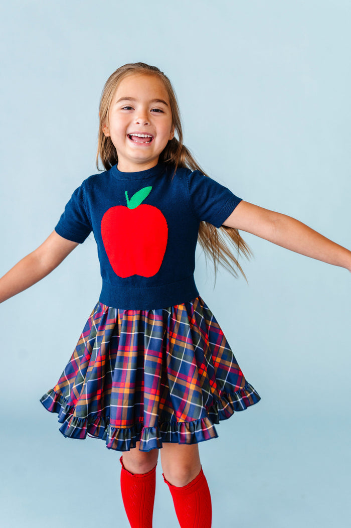 girl wearing back to school apple sweater with matching navy plaid twirl dress