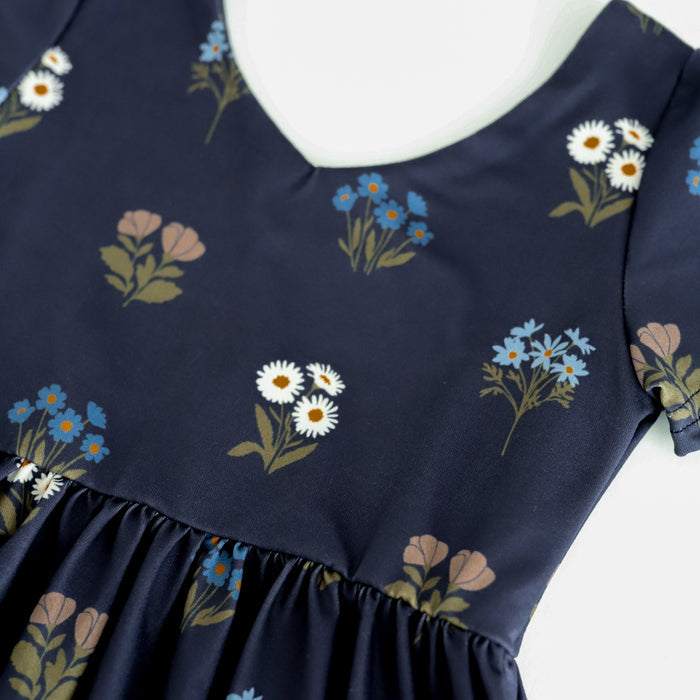 closeup of floral print detail on girls' v-neck twirl dress bodice in navy