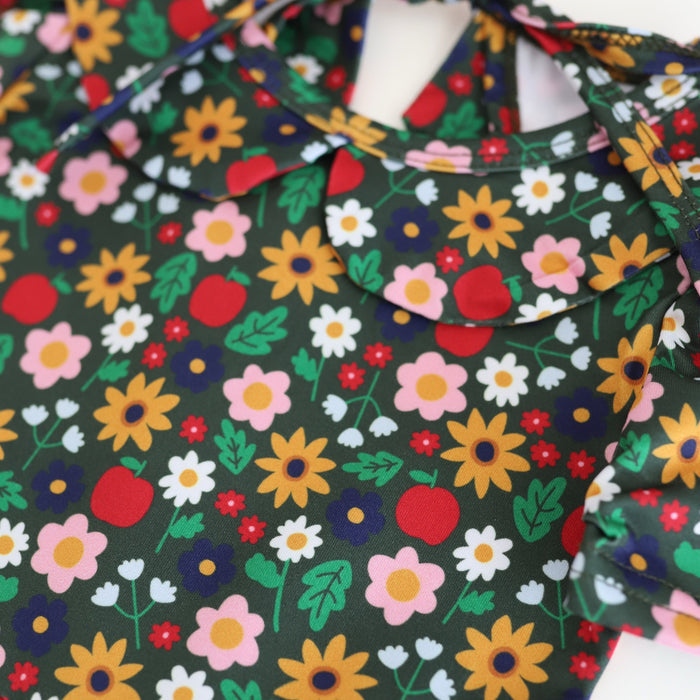 closeup of girls' apple and floral print dress in shades of green, yellow, red and navy to match back to school collection