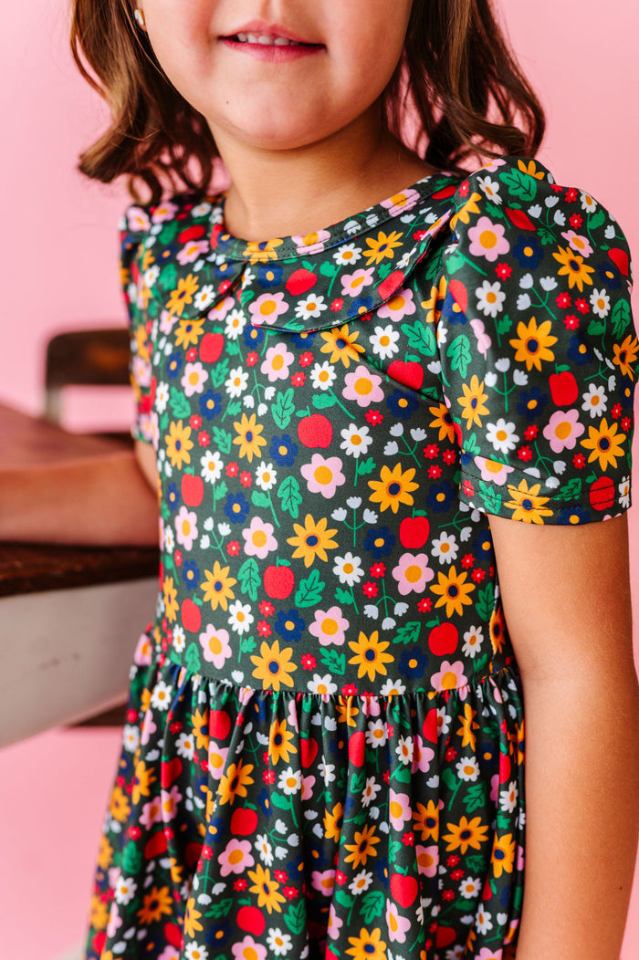 print detail of back to school flowers and apples dress, forest green dress with colorful flowers and red apples