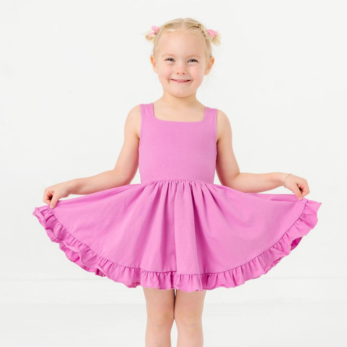 little girl posing in orchid purple sleeveless twirl dress for summer