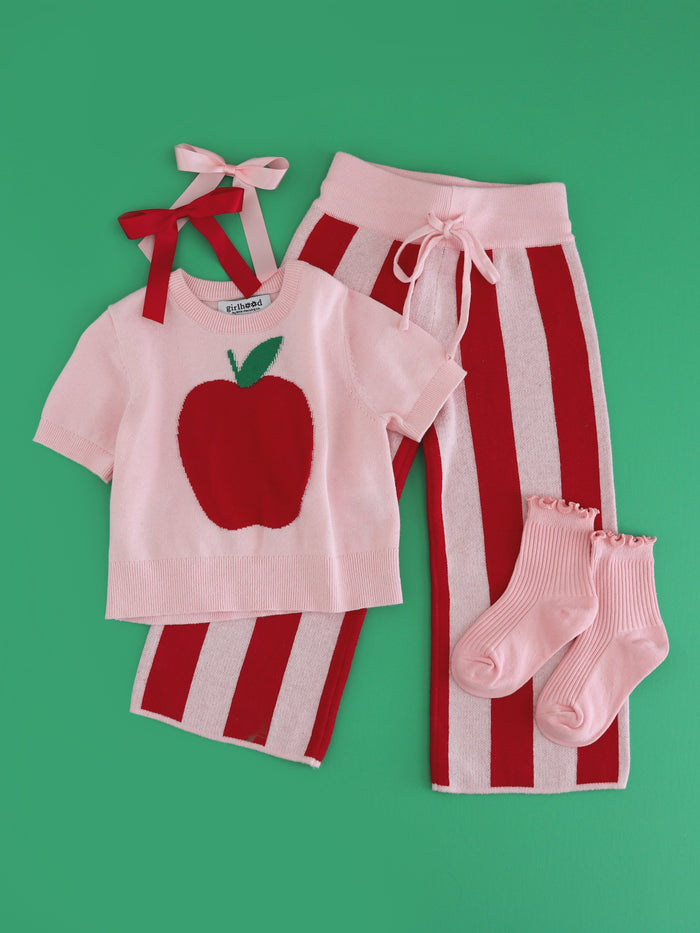 girls' apple themed sweater set with pink short sleeve apple sweater, coordinating red and pink striped sweater pants and matching midi socks and satin bows