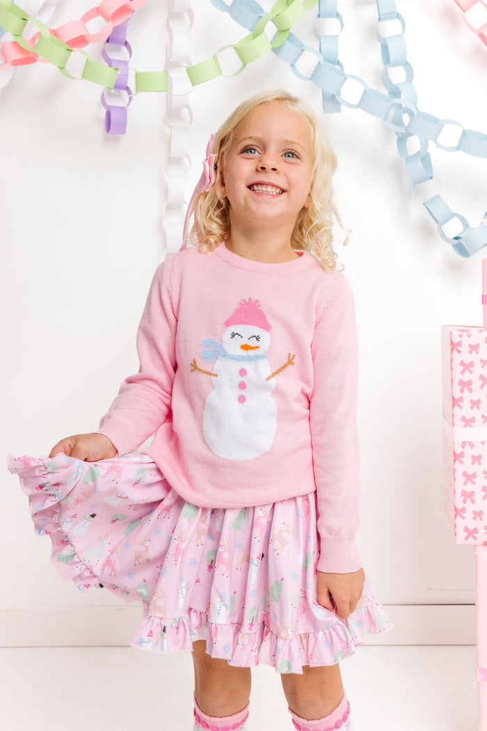 little girl wearing pink cotton knit sweater with snowgirl design paired with pastel pink winter wonderland print twirl dress for pink Christmas
