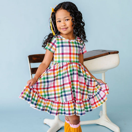 girl wearing rainbow primary color gingham plaid dress for back to school