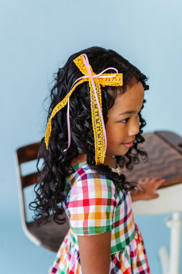 Girl wearing yellow and pink hair bow for back to school