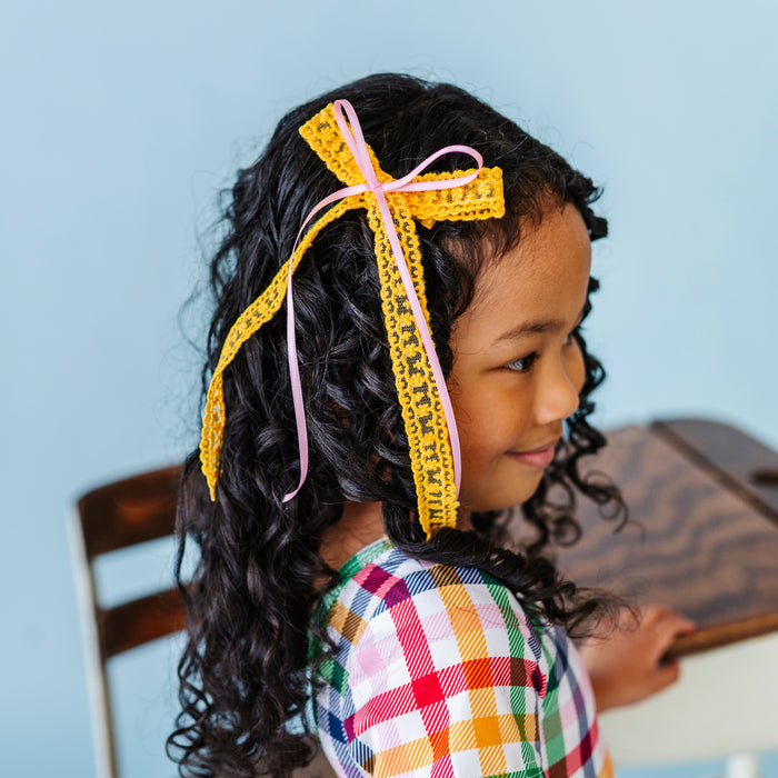 girl in yellow lace long tail bow with light pink satin ribbon for pencil inspired color palette paired with primary gingham twirl dress for back to school