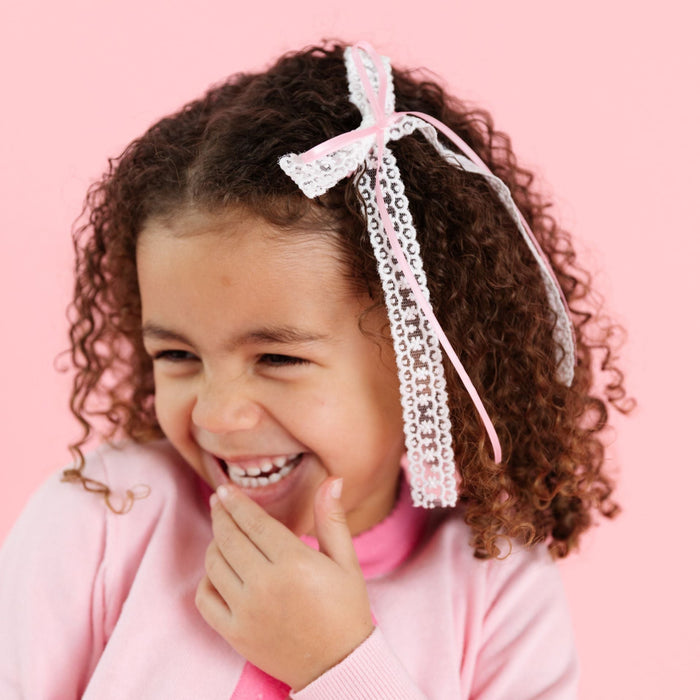 little girl in spring double hairbow with dainty light pink satin ribbon layered over white lace to match two-tome pink cardigan