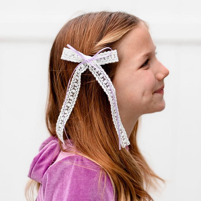 girl in long tail white lace hair bow with skinny lavender ribbon detail on alligator clip to match pink and purple valentine's collection