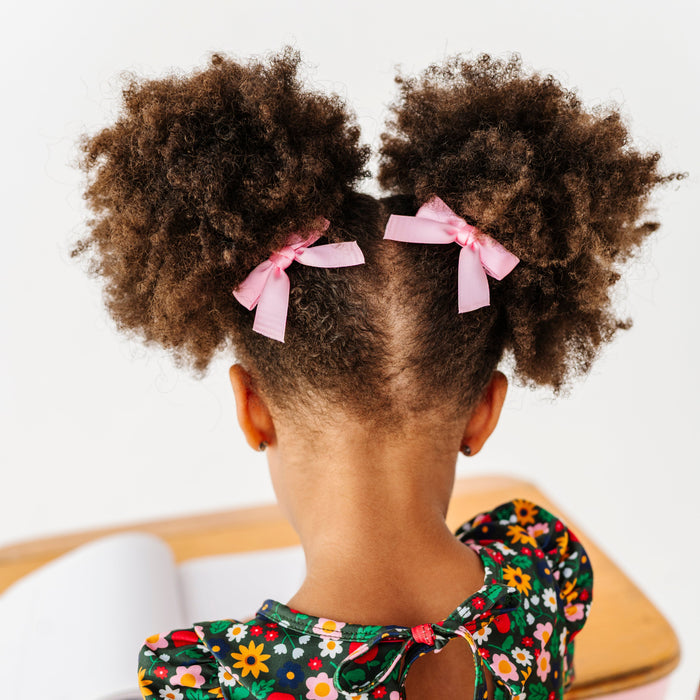 little girl in light pink satin pigtails bows on clips styled with orchard print twirl dress