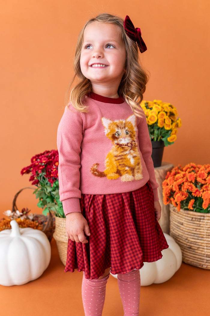 little girl in front if fall flower baskets in rust gingham twirl dress and old rose sweater with cute kitten design