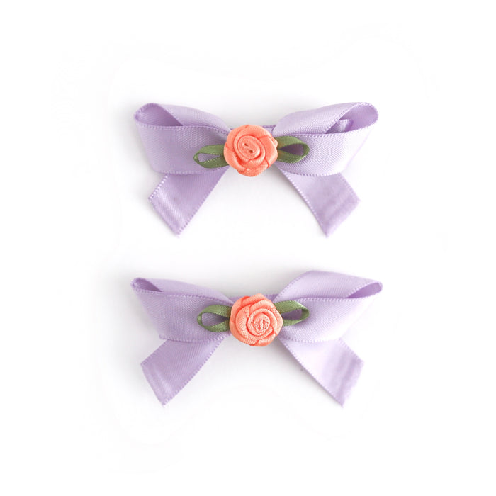two lavender satin ribbon hair bows with peach rosette embellishments on clips for pigtails