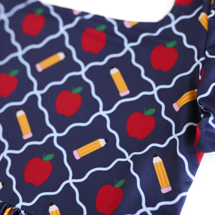 close up of navy-blue dress bodice with red apples and yellow pencil print